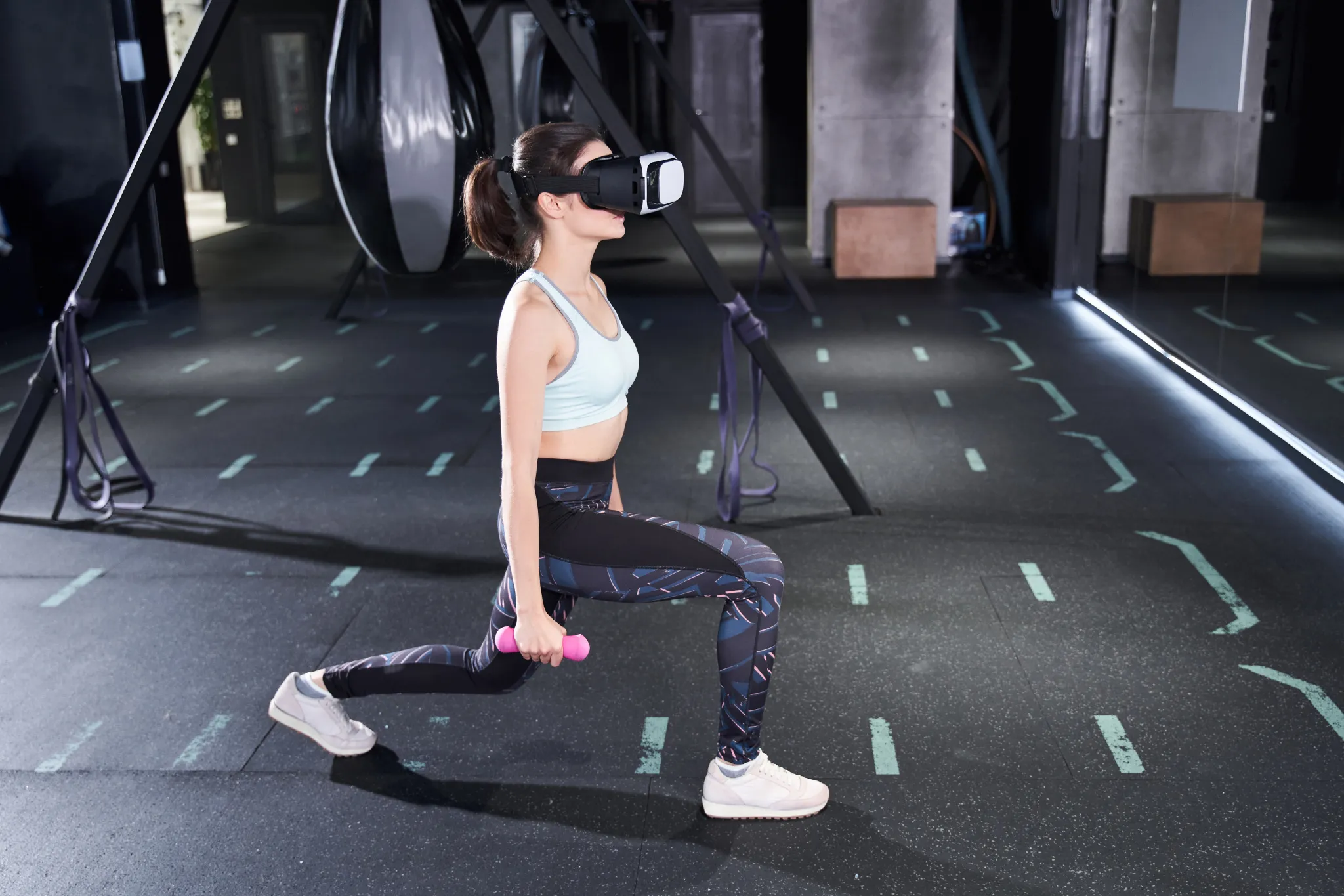 Athlete wearing a VR headset and holding a dumbbell in a lunge